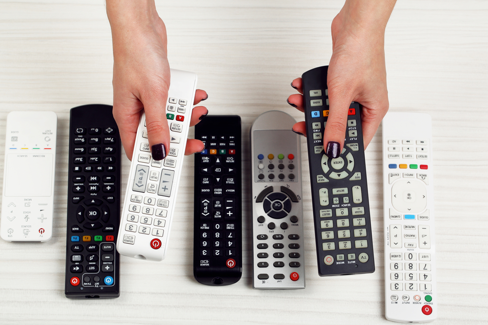 Two hands with different remotes  