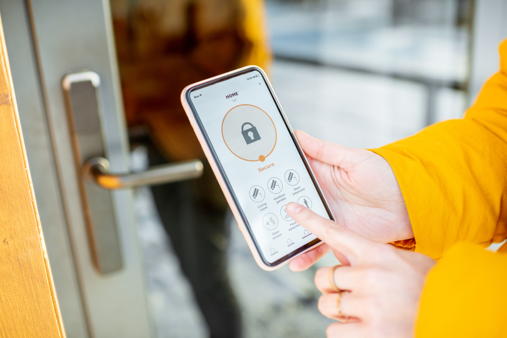 Person using smartphone app to control smart lock on door